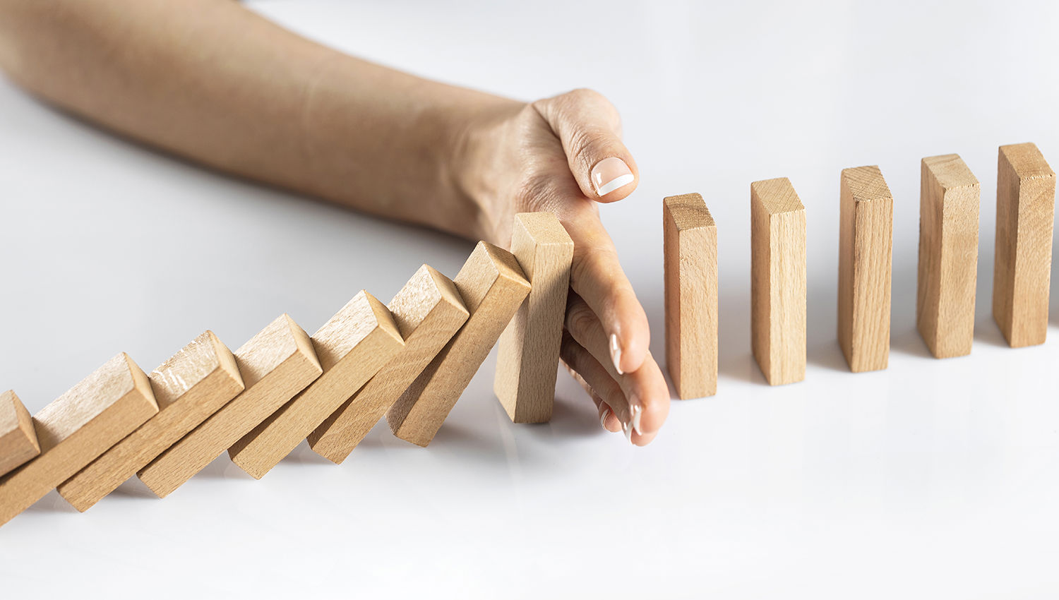 Hånd stopper dominobrikker