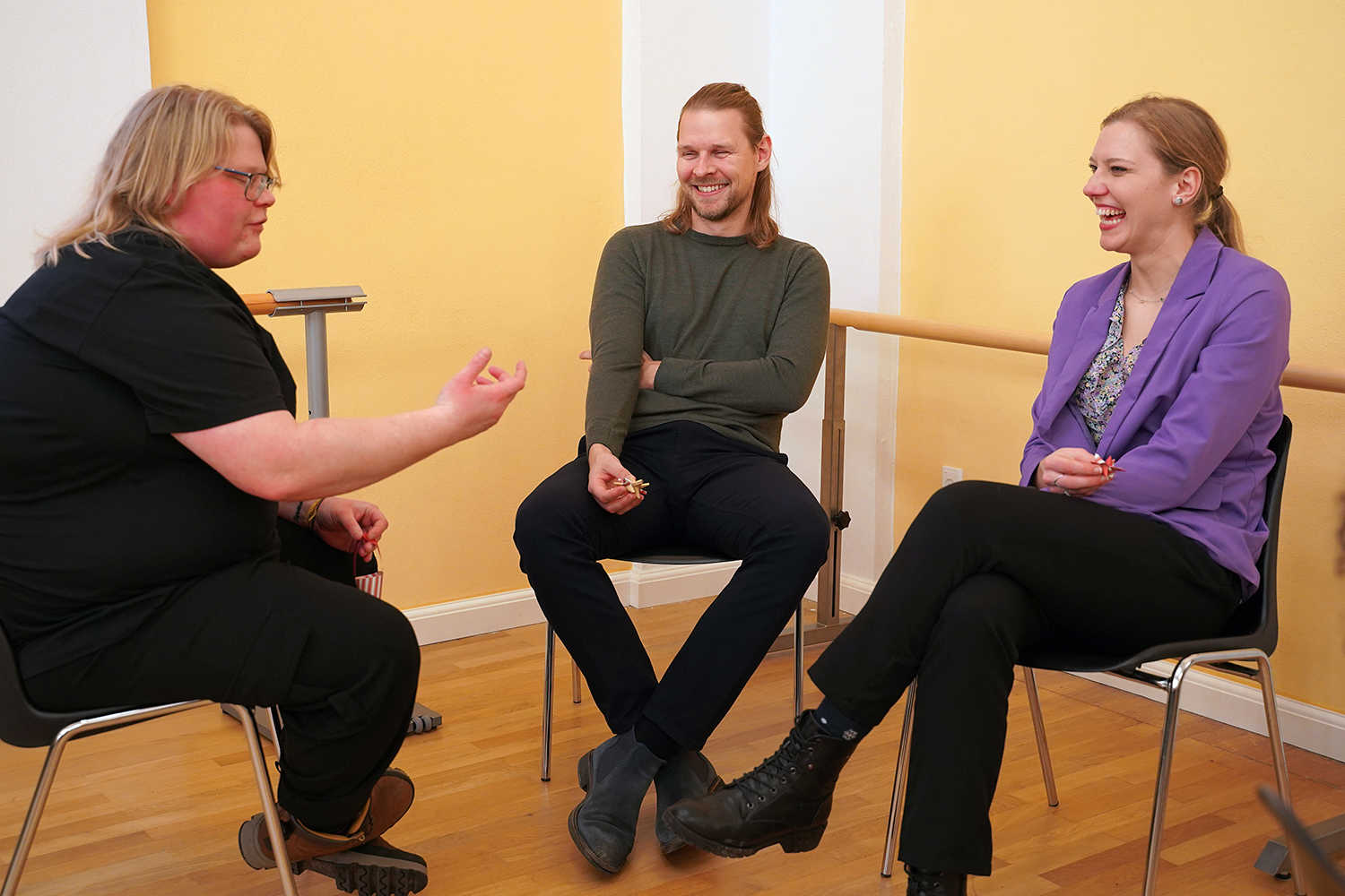 Tre unge mennesker sidder og taler sammen